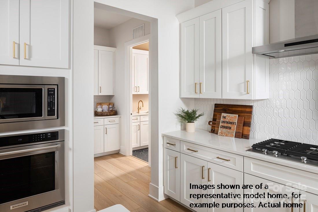 1049 Pinecone Avenue, Unit 218 Indian Land, SC 29707 - Photo 7 of 21 a kitchen with stainless steel appliances granite countertop a stove a microwave and a refrigerator