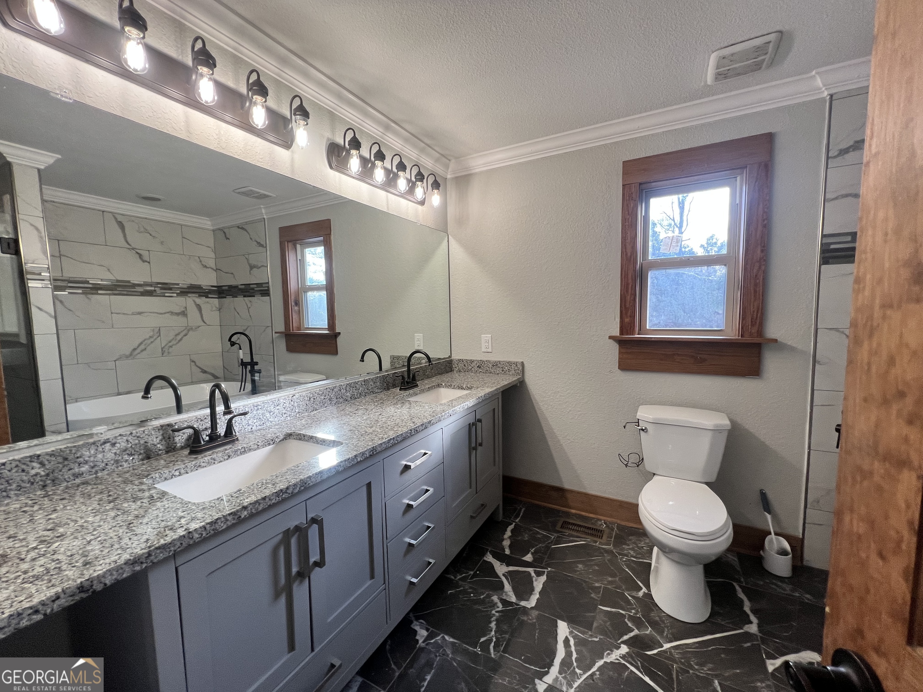 343 Morrison Street Mount Vernon, GA 30445 - Photo 16 of 22 a bathroom with a granite countertop toilet a sink and a mirror