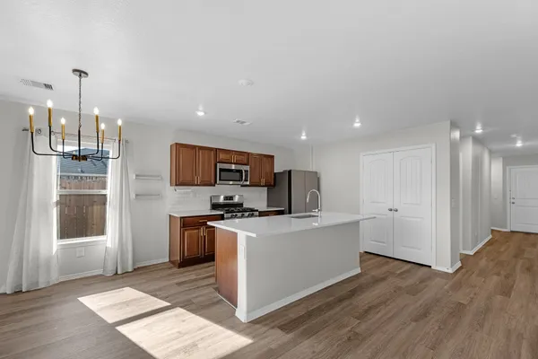 a kitchen with stainless steel appliances a stove top oven a sink a window and a refrigerator