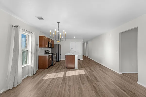 a kitchen with stainless steel appliances a refrigerator and a wooden floor