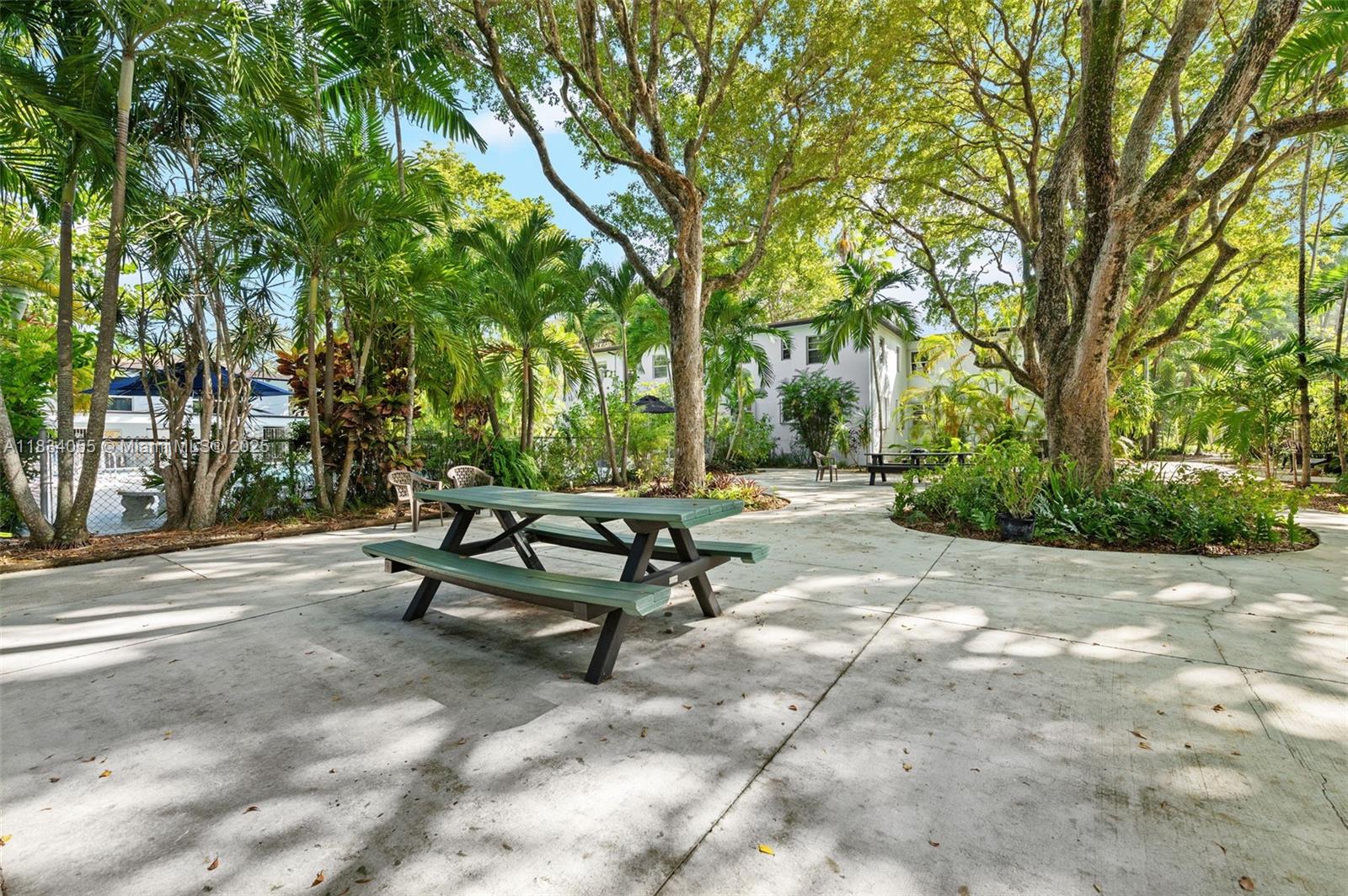 7865 Southwest 57th Avenue, Unit 48D South Miami, FL 33143 - Photo 15 of 22 a bench sitting in middle of a yard