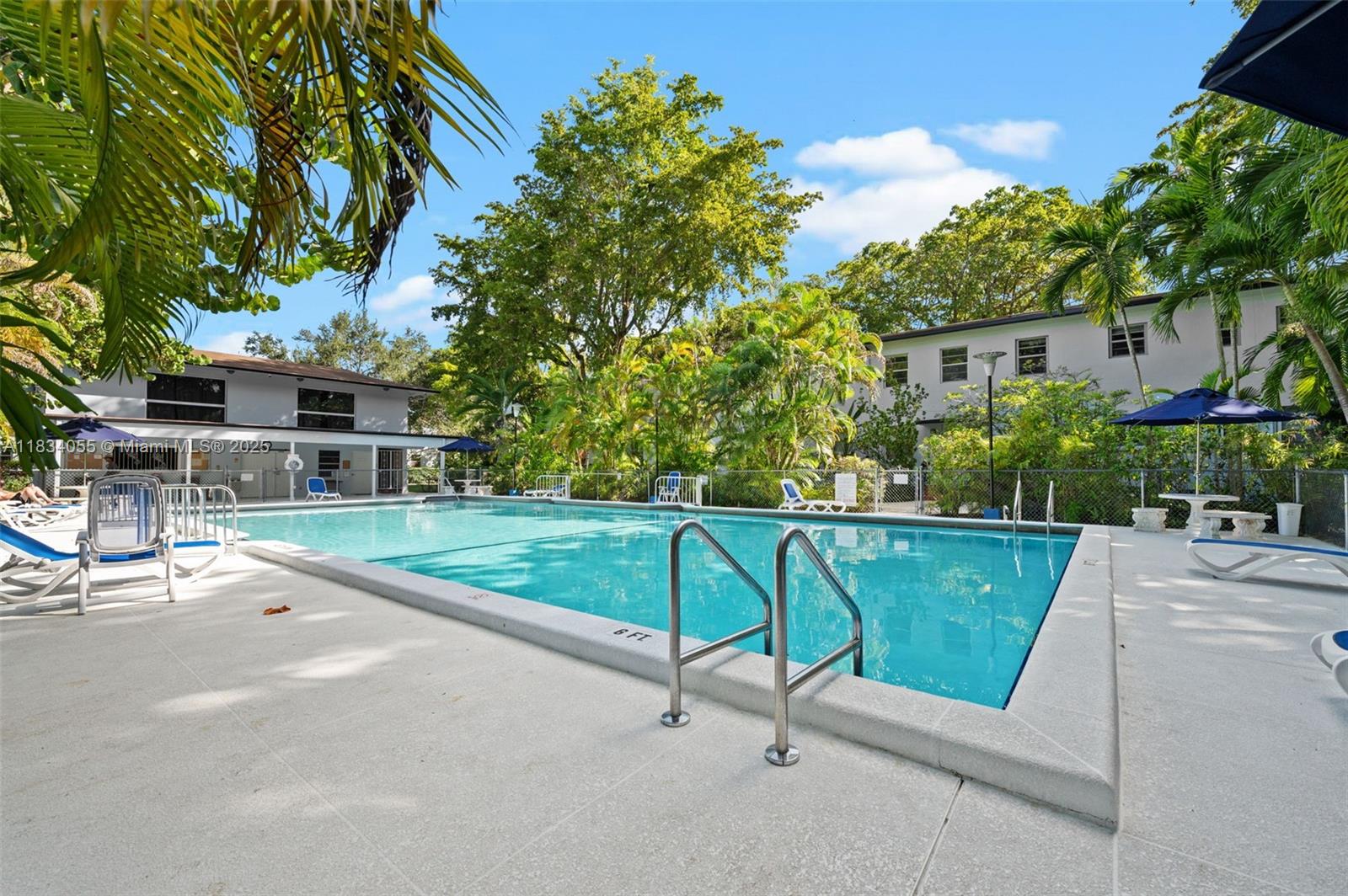 7865 Southwest 57th Avenue, Unit 48D South Miami, FL 33143 - Photo 16 of 22 a view of a patio with a table and chairs under an umbrella