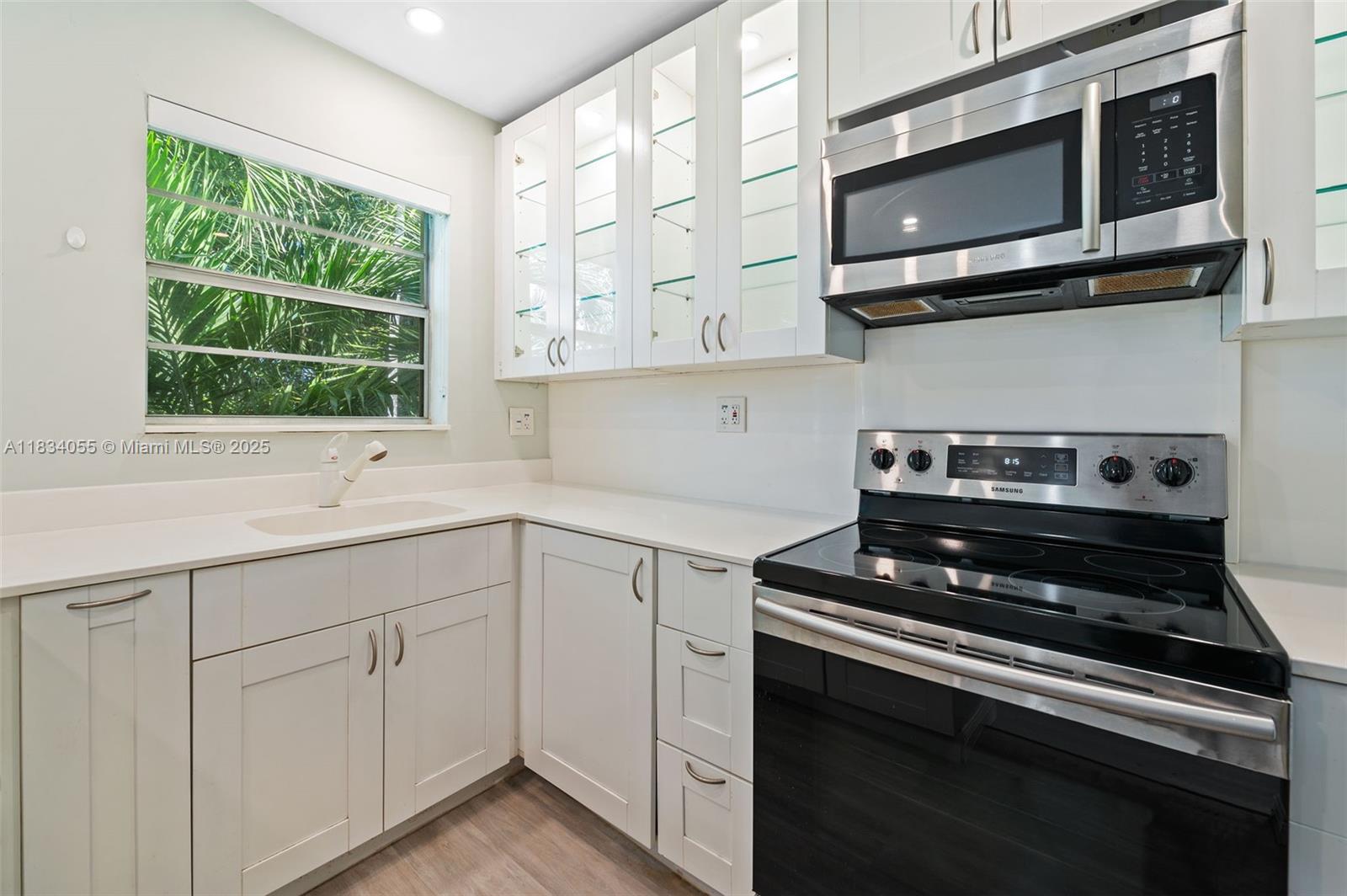 7865 Southwest 57th Avenue, Unit 48D South Miami, FL 33143 - Photo 7 of 22 a kitchen with stainless steel appliances white cabinets and a stove top oven