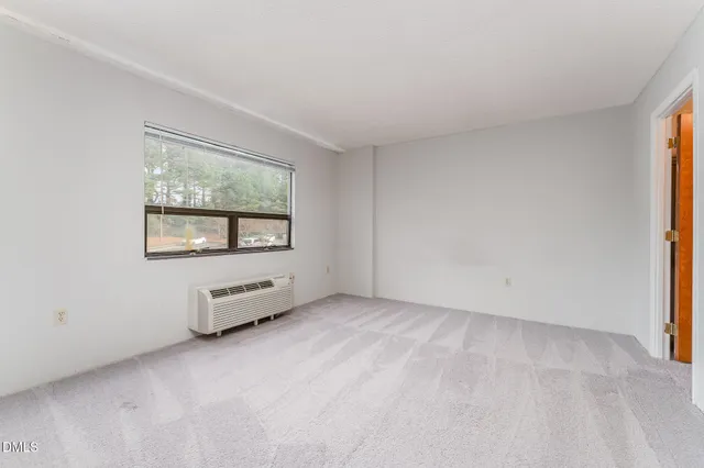 an empty room with a window and a bathroom