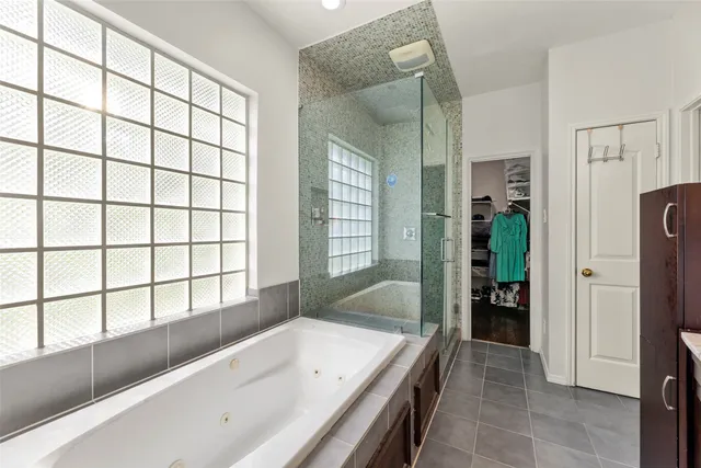 a bathroom with a granite countertop tub sink and mirror