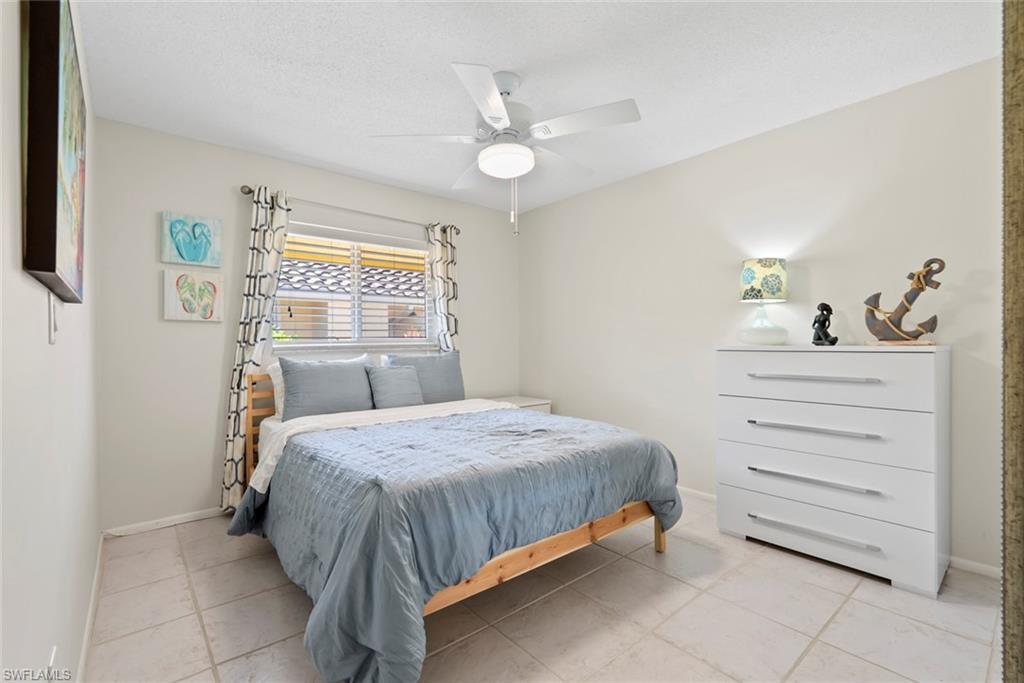136 Harrison Road, Unit 1 Naples, FL 34112 - Photo 13 of 29 Bedroom featuring light neutral wall tones and square tile flooring