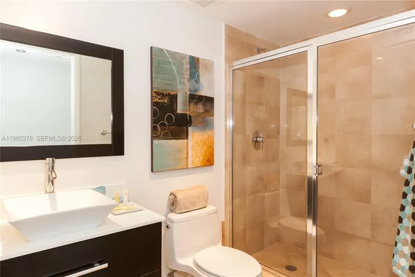 a bathroom with a sink toilet a mirror and shower