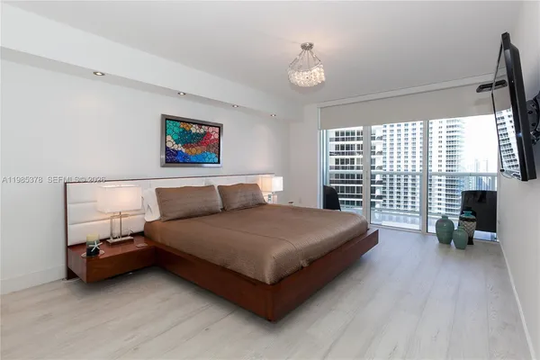 a bedroom with a bed and a chandelier