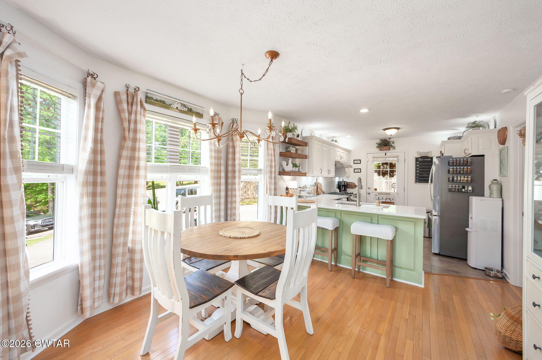 455 Madison Scott Road Parsons, TN 38363 - Photo 10 of 45 a dining room with stainless steel appliances kitchen island granite countertop a refrigerator a stove a dining table and chairs with wooden floor