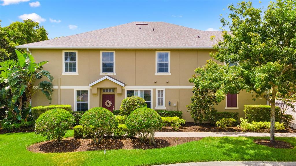 a front view of a house with a yard and potted plants