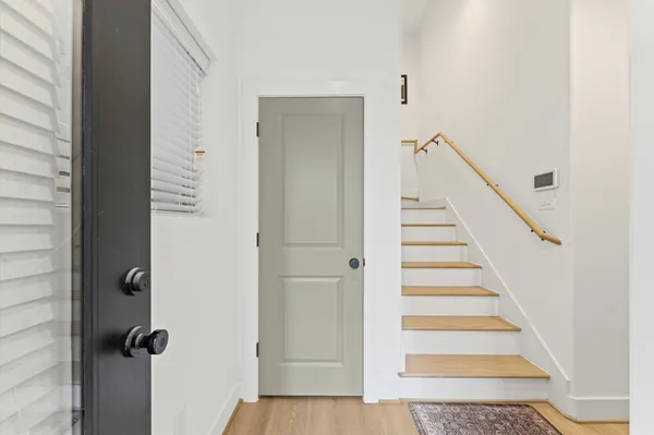 a view of a hallway with wooden floor and entryway