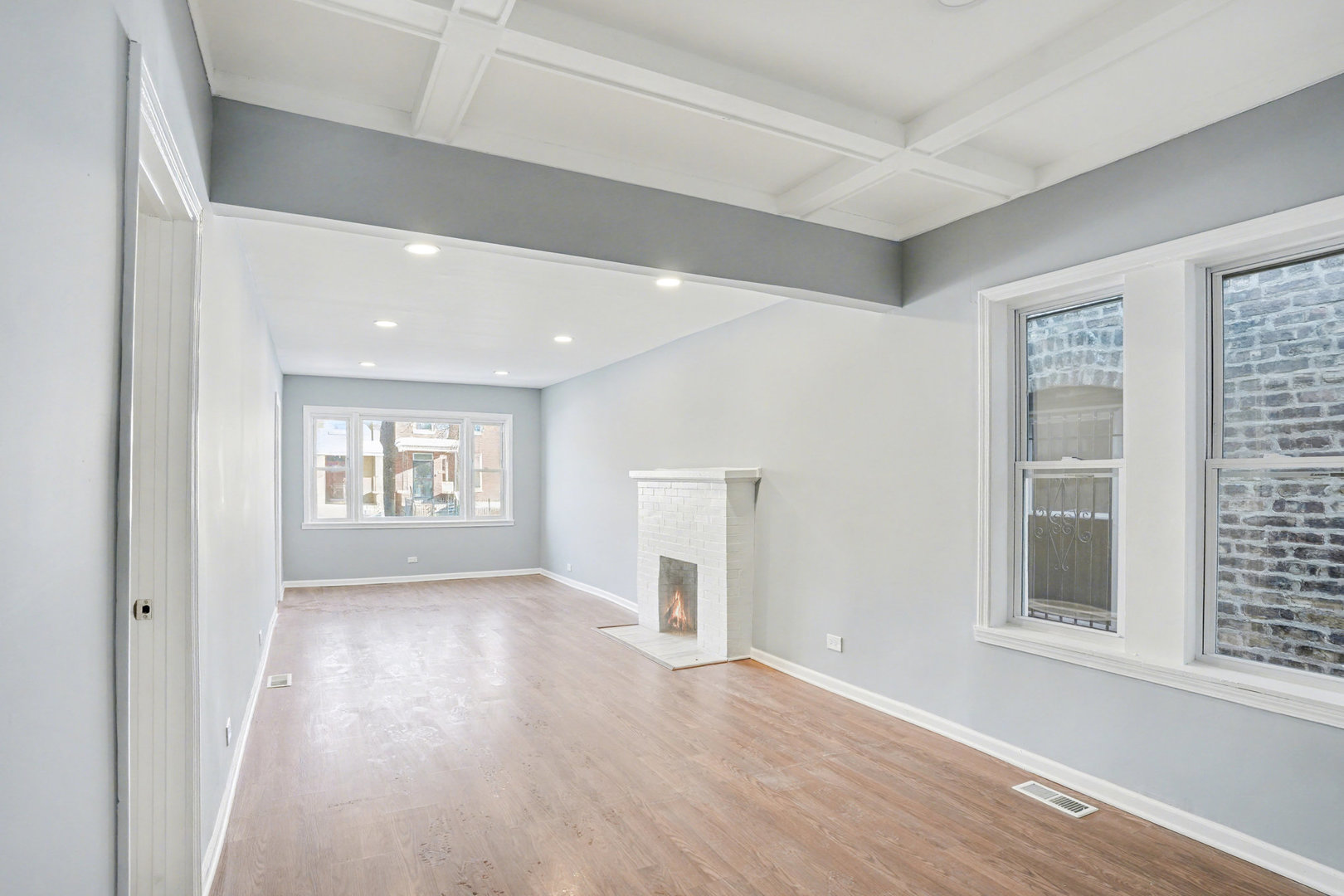 6954 South Prairie Avenue Chicago, IL 60637 - Photo 3 of 15 an empty room with a fireplace and windows