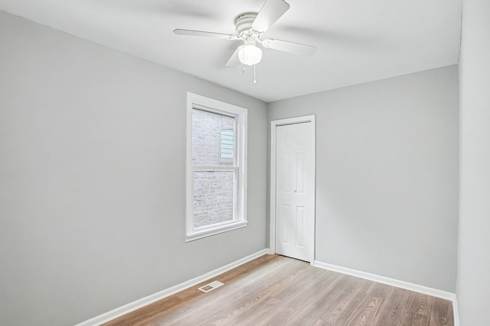 6954 South Prairie Avenue Chicago, IL 60637 - Photo 7 of 15 an empty room with windows and fan