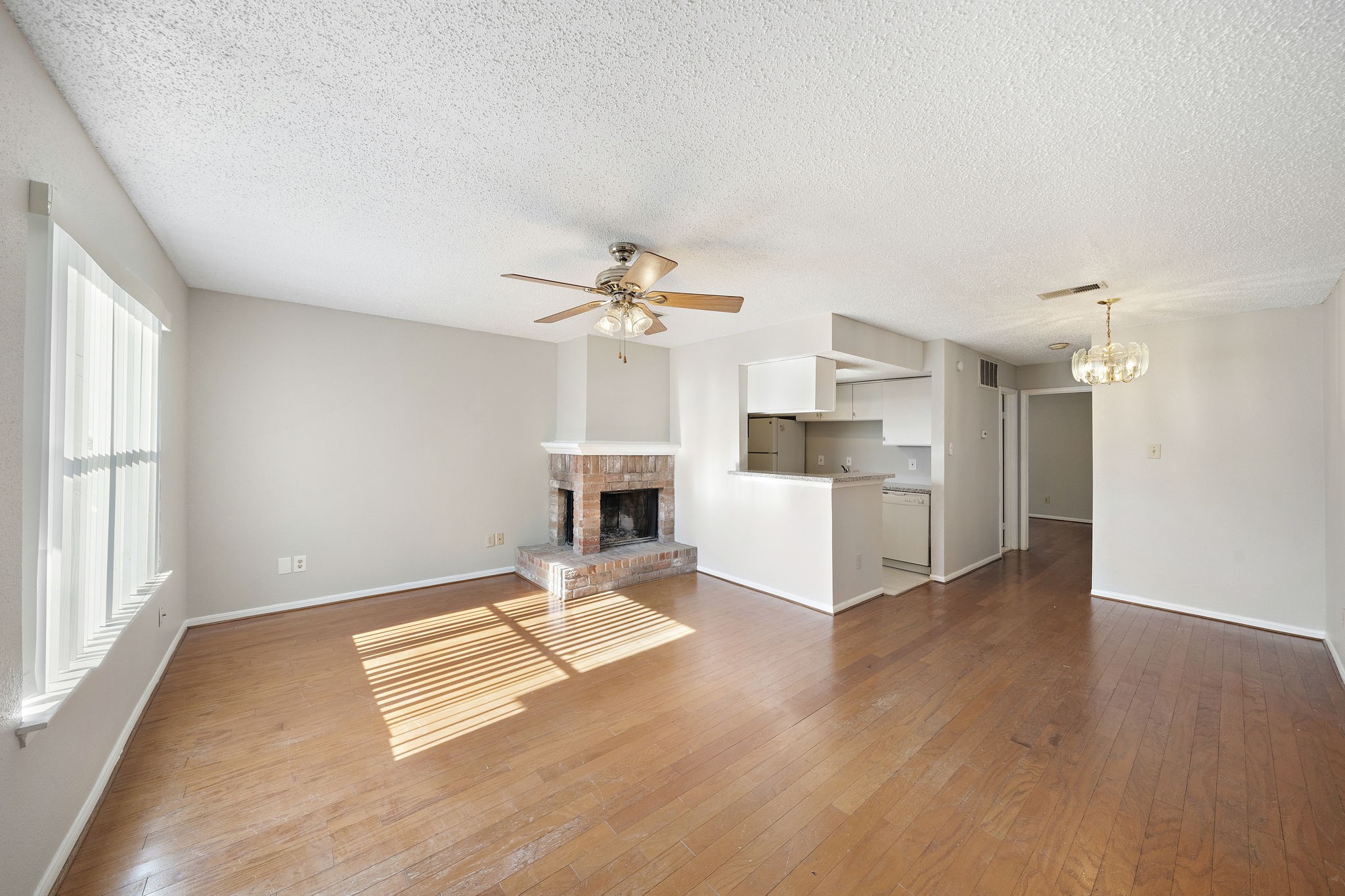 7402 Alabonson Road, Unit 506 Houston, TX 77088 - Photo 3 of 10 a living room with couches and kitchen view with wooden floor