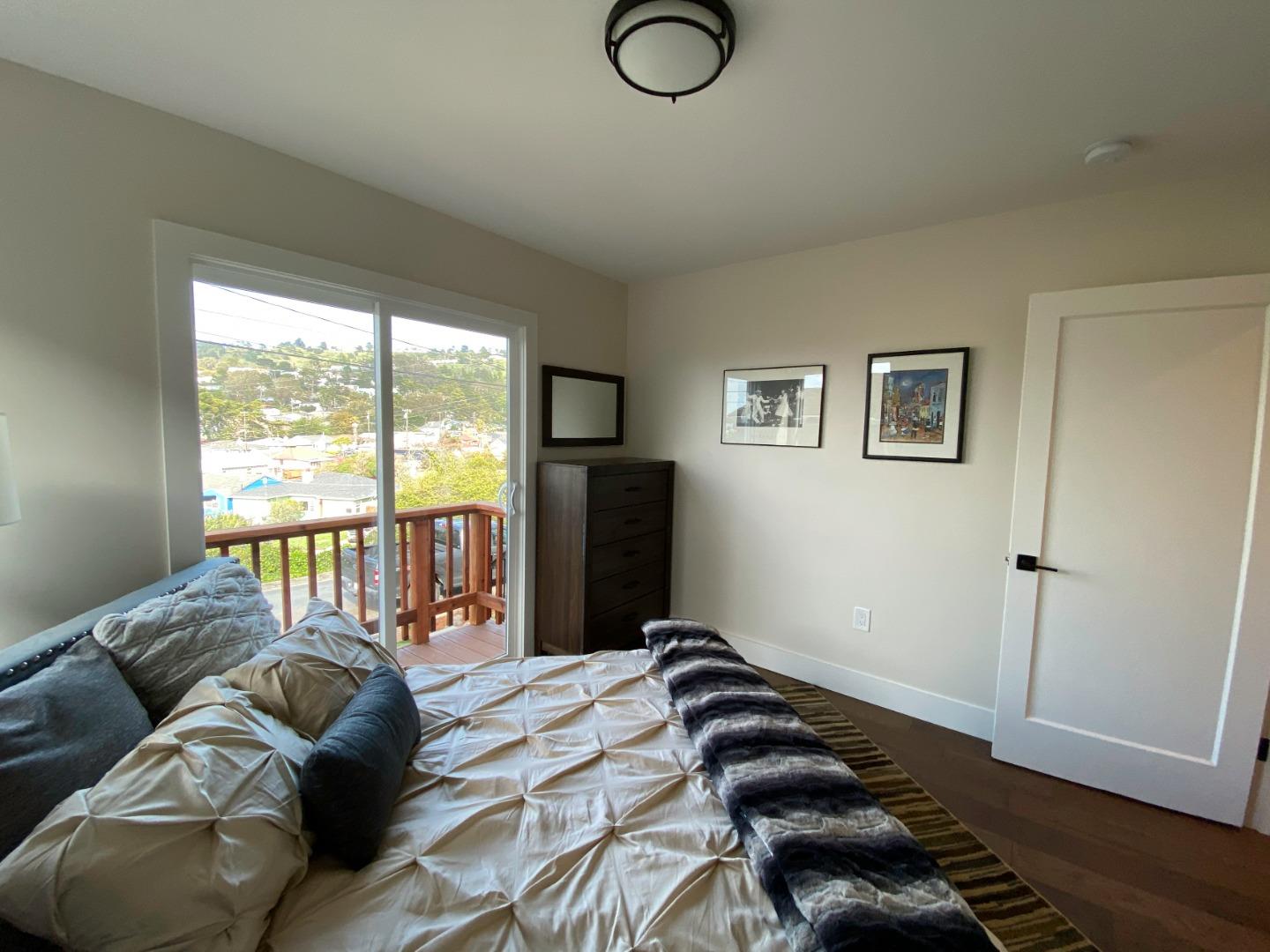 660 Edgemar Avenue Pacifica, CA 94044 - Photo 11 of 36 a bedroom with a bed and wooden floor