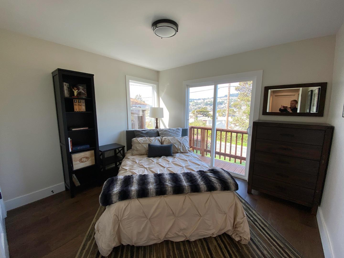660 Edgemar Avenue Pacifica, CA 94044 - Photo 10 of 36 a bedroom with a bed and wooden floor