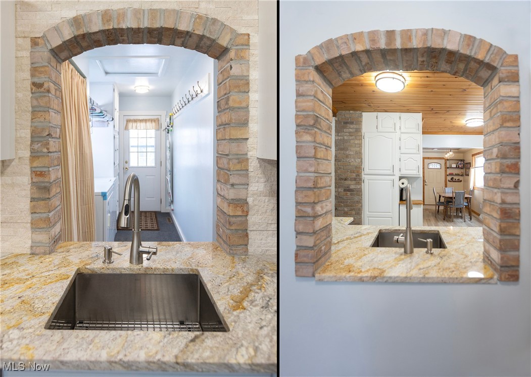 253 Sunset Road Avon Lake, OH 44012 - Photo 15 of 33 Kitchen with arched walkways, a sink, light stone countertops, and white cabinets