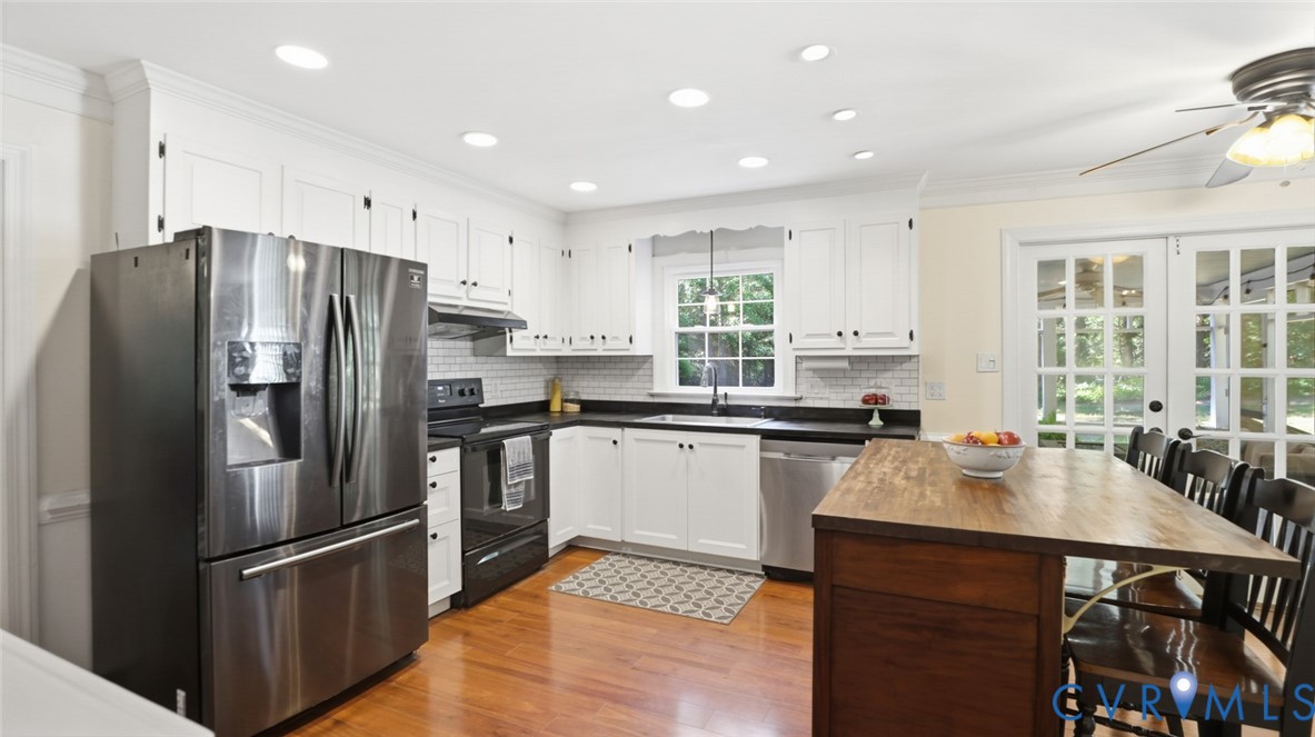 10716 Chalkley Road Richmond, VA 23237 - Photo 2 of 46 a kitchen with stainless steel appliances a refrigerator a sink a stove a dining table and chairs
