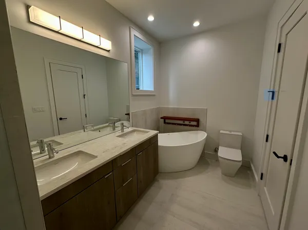 a bathroom with a double vanity sink toilet and mirror