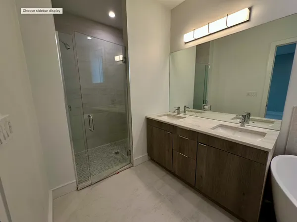 a bathroom with a double vanity sink mirror and shower
