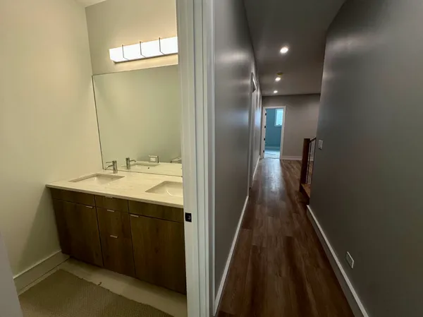 a view of a hallway with wooden floor and staircase