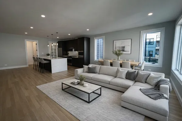 a living room with furniture kitchen and a table