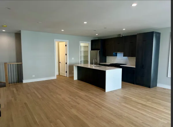a kitchen with stainless steel appliances kitchen island granite countertop a refrigerator and a sink