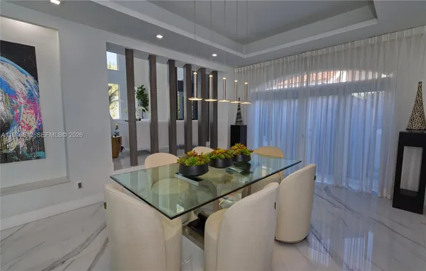 a view of a dining room with furniture a chandelier and wooden floor