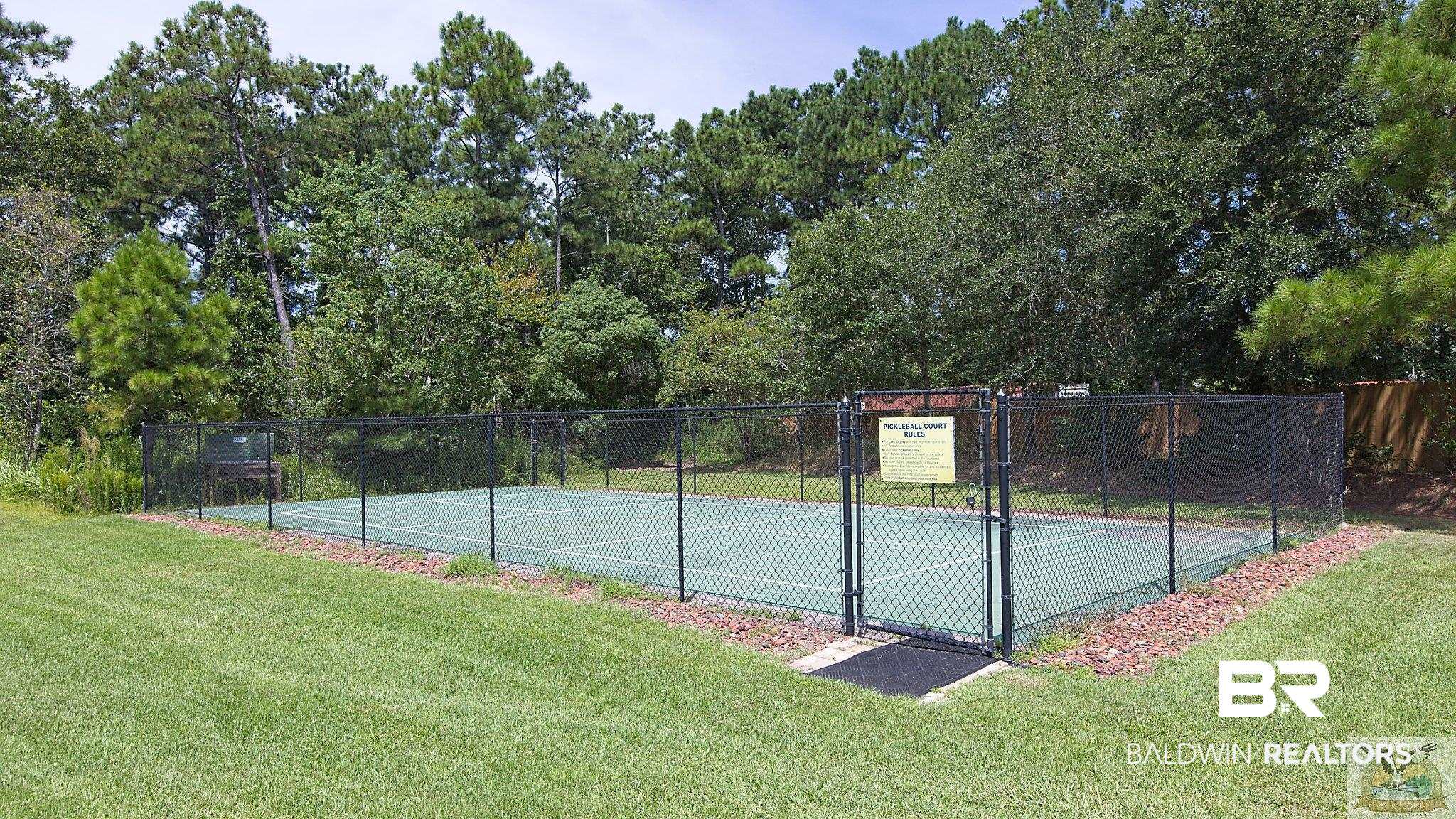 28058 Migratory Way, Unit 100 Elberta, AL 36530 - Photo 81 of 83 View of sport court with a lawn and fence