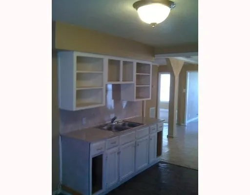 a kitchen with granite countertop a sink and a stove