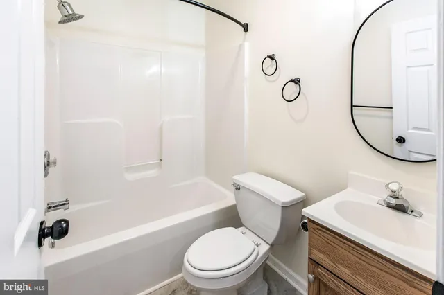 a white toilet sitting next to a bathroom sink and tub