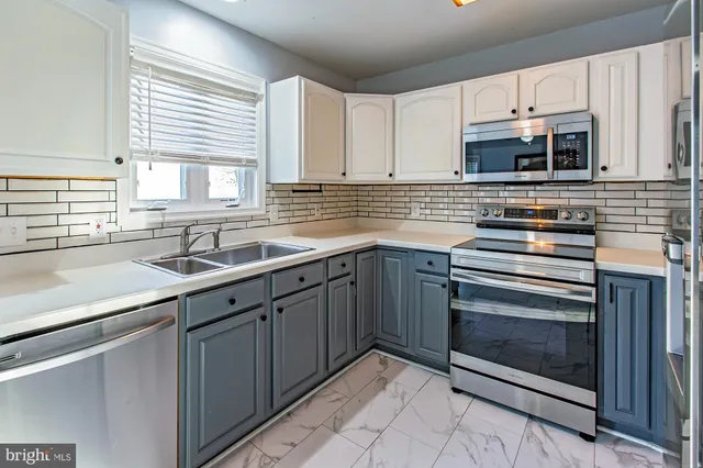 a kitchen with stainless steel appliances a stove sink and microwave