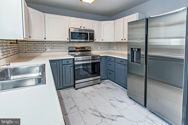 a kitchen with stainless steel appliances granite countertop a stove a refrigerator and a sink