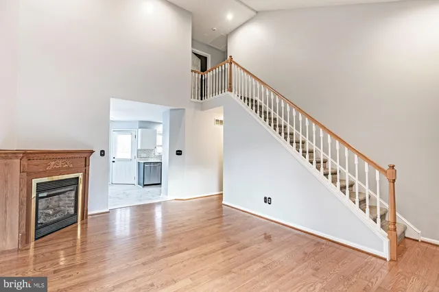 a view of a livingroom with wooden floor and stairs