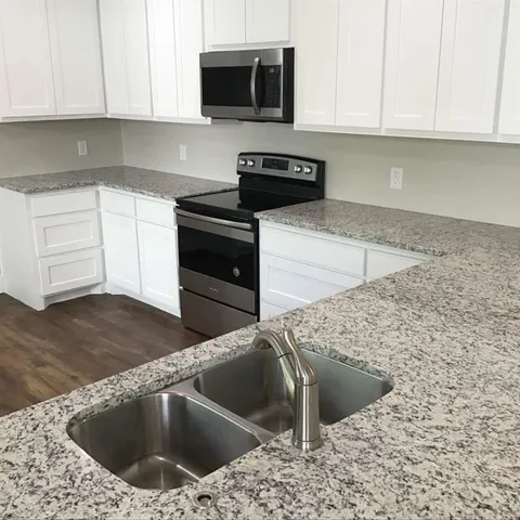 a kitchen with a sink stove and microwave