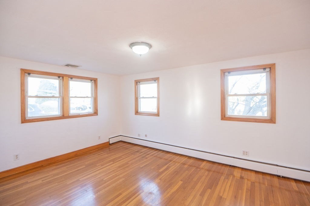 3 Pershing Road Salem, MA 01970 - Photo 17 of 38 a view of an empty room with wooden floor and a window