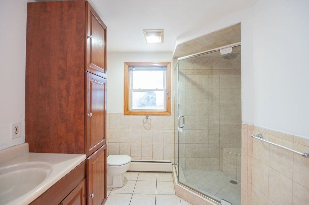 3 Pershing Road Salem, MA 01970 - Photo 29 of 38 a bathroom with a granite countertop shower a toilet and a sink