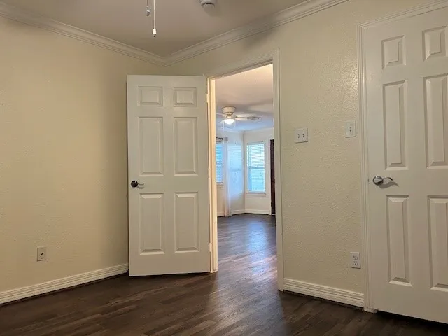 an empty room with wooden floor and closet area