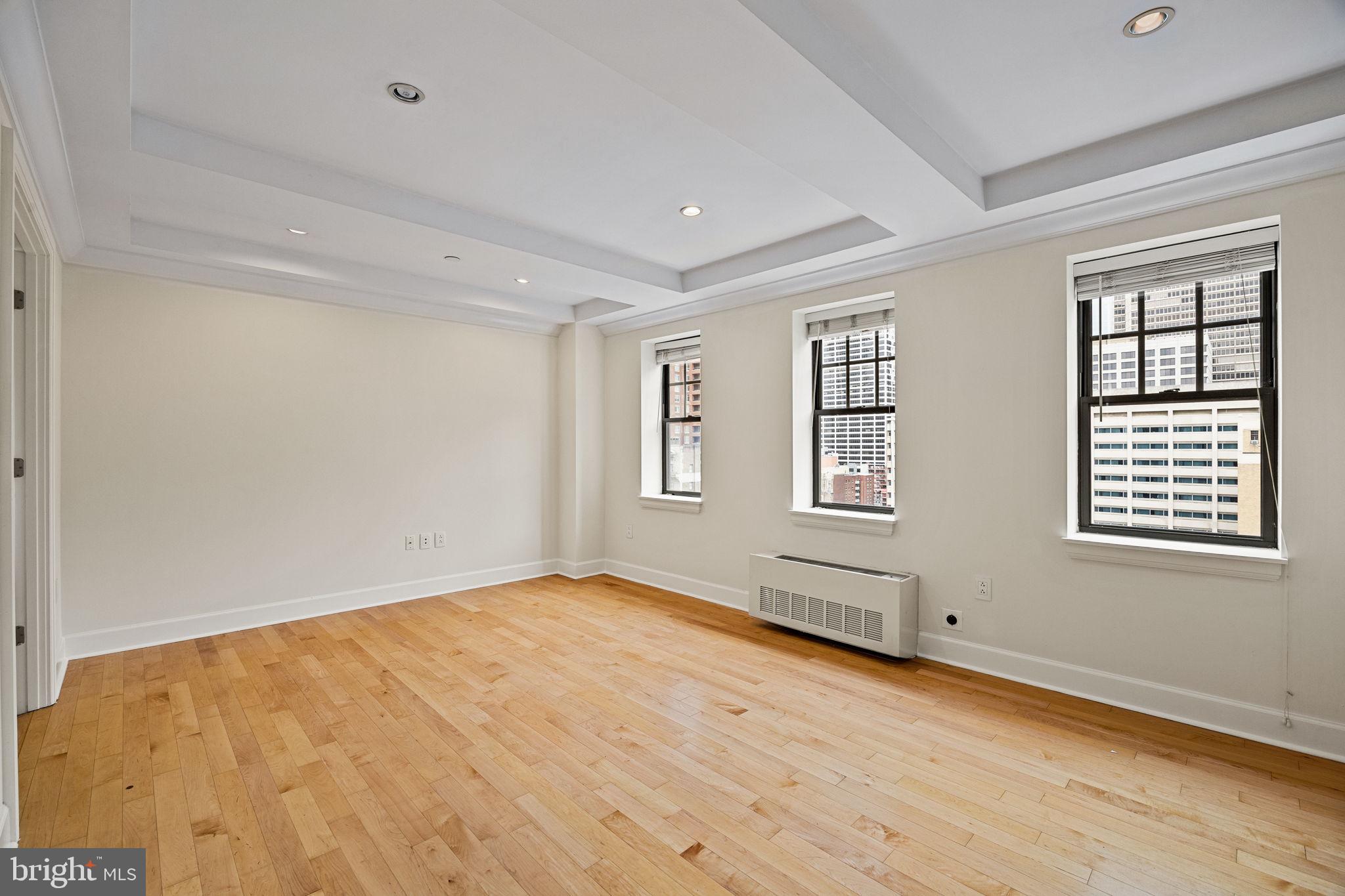 1701 Locust Street, Unit 1602 Philadelphia, PA 19103 - Photo 2 of 28 a view of an empty room with wooden floor and a window