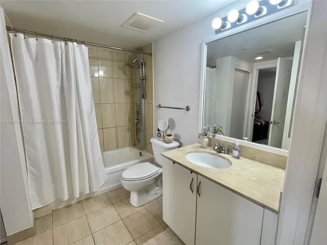 a bathroom with a sink a toilet a mirror and shower curtain