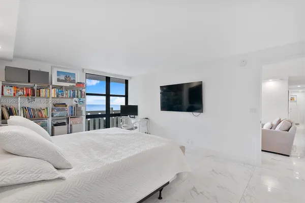 a large bedroom with a bed and a flat screen tv