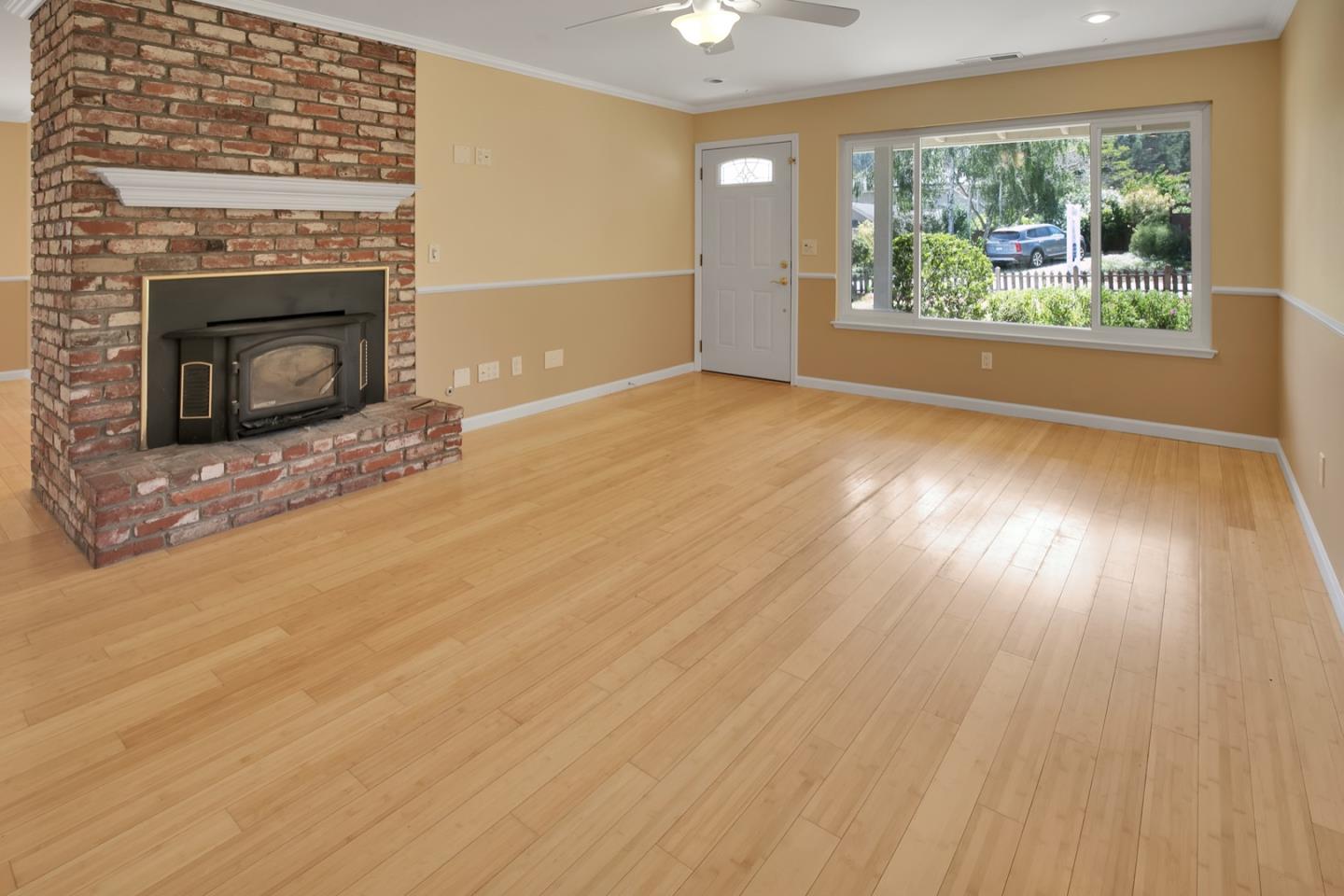 210 Hames Road Corralitos, CA 95076 - Photo 6 of 17 an empty room with wooden floor fireplace and windows