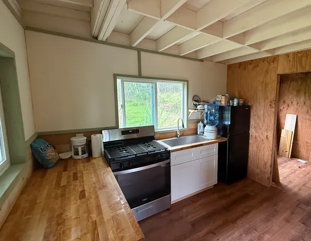 a kitchen with a stove a refrigerator and a wooden cabinets