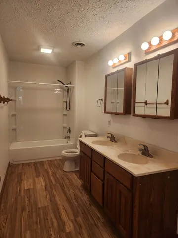a bathroom with a sink a toilet a mirror and shower