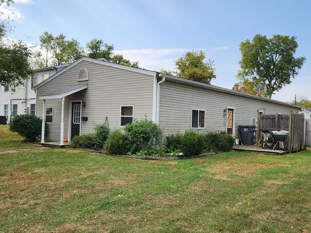 a view of a house with a patio and a yard