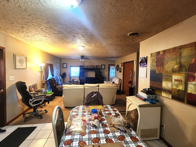a living room with furniture and a dining table with kitchen view
