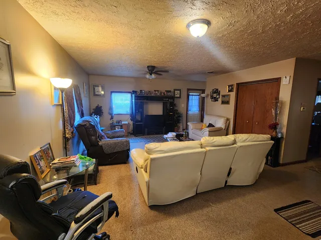 a living room with furniture a ceiling fan and a window