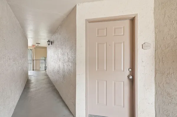 a view of a hallway with white cabinets and wooden floor