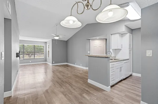 a kitchen with a white cabinets and chandelier