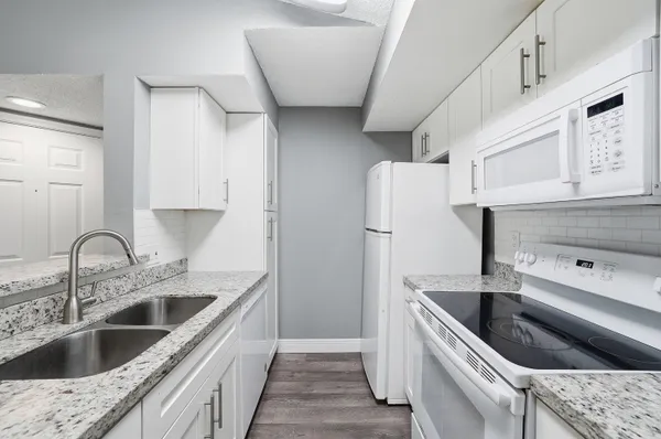 a kitchen with a sink dishwasher a refrigerator and cabinets